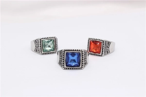 Macro detail of retro men's steel rings with Greek fret patterns and colorful square gemstones