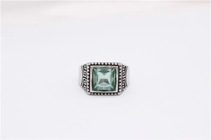 Detailed view of square green gemstone on men's ring with Greek meander engraving