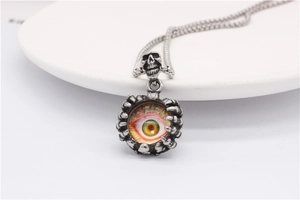 Macro shot of gothic evil eye pendant with skull and claw details on vintage steel chain