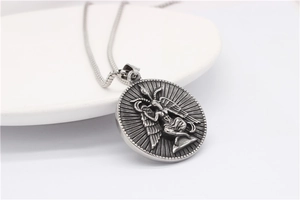 Close-up of retro Baphomet winged goat head pendant on polished steel chain