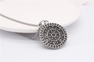 Détail du pendentif ancre vintage avec motif de gouvernail et chaîne vénitienne