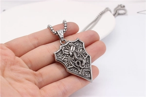 Close-up of retro stainless steel dragon shield pendant necklace with vintage matte finish