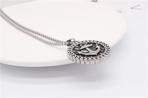 Détail macro du pendentif médaillon ancre vintage en acier avec chaîne à mailles