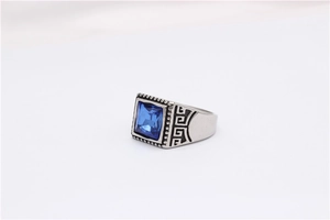 Detailed macro shot of vintage steel ring with blue square gemstone and meander pattern