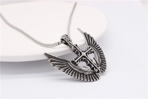Detail of gothic cross and angel wings pendant with vintage blackened steel texture