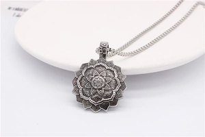 Macro shot of vintage silver lotus mandala pendant with intricate engraved details