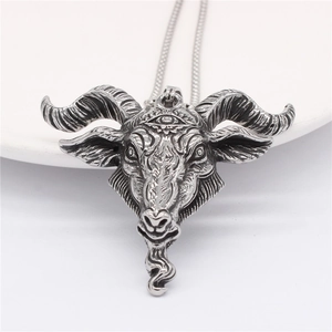 Vintage silver gothic ram head pendant necklace with third eye detail on a white plate