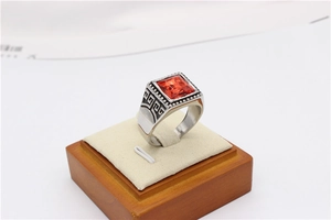 Macro view of vintage silver ring with orange gemstone and Greek key patterns
