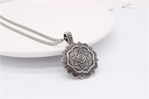 Detailed macro view of retro stainless steel lotus mandala pendant with sacred Om symbol