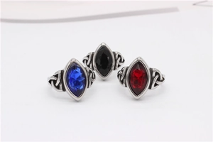 Close-up of Viking Celtic rings with red, blue, and black marquise stones and vintage texture