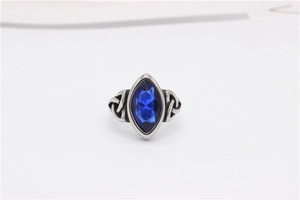 Close-up of Marquise-cut blue gemstone ring with intricate Celtic knot engraving detail