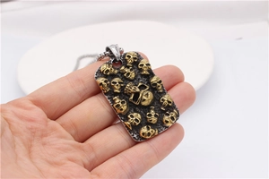 Détail d'un pendentif plaque de soldat punk vintage avec reliefs dorés et texture noire