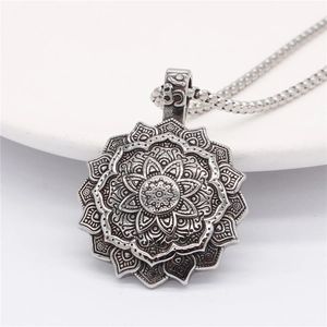 Vintage silver lotus mandala pendant necklace with Om symbol on polished ceramic tray