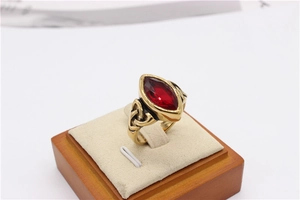 Macro shot of gold viking ring with marquise red gemstone and celtic knot details