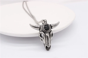 Close-up of retro ram skull pendant with black gemstone and ornate horn texture