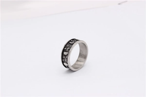 Macro shot of retro star and moon embossed patterns on oxidized silver titanium steel ring