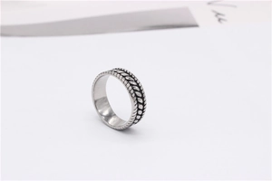 Detailed close-up of retro wheat pattern engraving on a vintage steel band ring