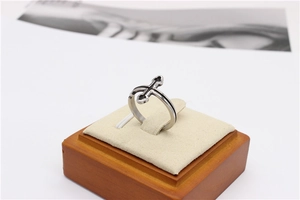 Détail d'une bague gothique avec croix en acier inoxydable sur un support en bois chic