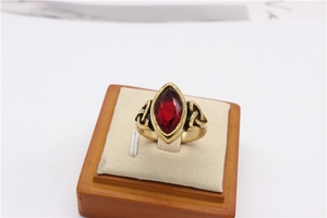 Detail of vintage gold ring with marquise red gemstone and Celtic knot carvings