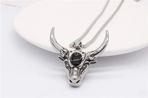 Detail of retro ram head pendant in stainless steel with black stone and snake chain