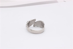 Close-up of vintage silver angel wing feather open ring with matte metallic texture