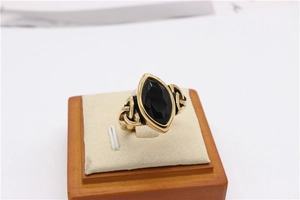 Detail view of Celtic knot gold ring with a marquise-cut black stone inlay