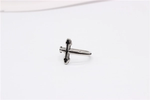 Détail d'une bague croix gothique vintage en métal argenté avec des accents oxydés noirs