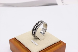 Detailed view of silver titanium steel ring with vintage braided texture on display