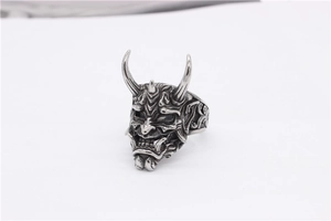 Macro detail of retro stainless steel Hannya mask ring with horn and fangs carvings