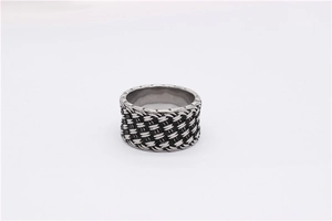 Macro shot of retro braided knot texture on wide stainless steel band with oxidized finish