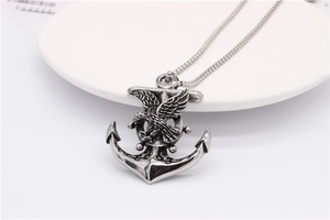 Detailed view of vintage silver eagle and anchor pendant on a sleek snake chain necklace