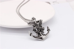 Close-up of vintage punk anchor and eagle pendant necklace in silver titanium steel