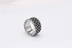 Macro detail of men's titanium steel ring featuring retro woven mesh texture and carved edges