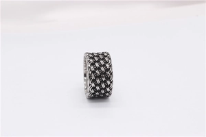 Detailed close-up of retro silver steel ring with woven knot texture and vintage pattern