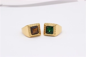 Detail of gold titanium rings with Greek meander patterns and square gemstone inlays