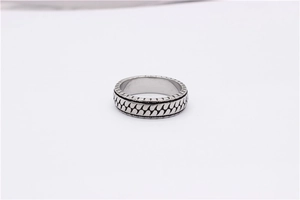 Macro shot of silver titanium steel ring featuring retro twill pattern and oxidized finish