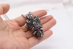 Vue détaillée du pendentif crâne gothique avec croix en strass rouge et chaîne