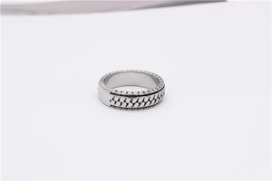 Detailed macro view of vintage silver steel ring with engraved black wave pattern texture