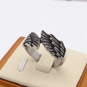 Vintage stainless steel angel wing feather ring with antique finish on a jewelry stand