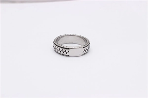 Close-up of vintage titanium steel ring featuring black geometric diagonal textured patterns