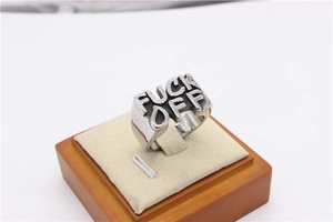 Detailed macro view of the punk style stainless steel signet ring with Fuck Off engraving
