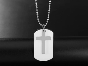 Detail view of a double-layered cross pendant necklace on a sleek black column stand