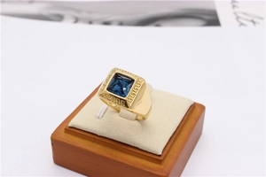 Macro shot of gold-plated ring with blue square gemstone and Greek fret pattern