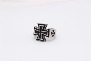 Macro shot of retro stainless steel cross ring with embossed details and aged metal finish