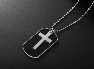 Close-up of men's cross pendant necklace with black dog tag on steel ball chain