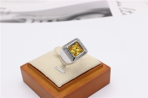 Macro shot of silver titanium ring with yellow citrine and Greek meander patterns