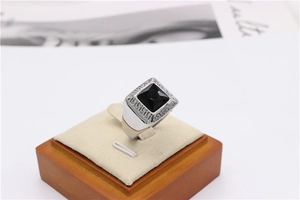 Macro view of silver titanium steel ring with black gemstone and Greek key patterns