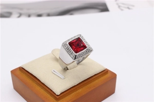 Macro shot of silver men's ring with large square ruby gemstone and Greek key pattern