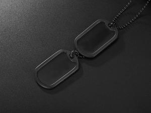 Detail of matte black double military dog tags with minimalist metal beaded chain