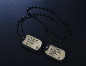 Detail of US Army military dog tag necklace with RAMBO engraving and black silencer